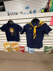Cub Scout shirt and Boy Scouts of America uniform shirt with neckerchief on display wall