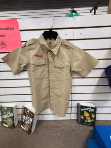 Boy Scouts of America uniform shirt hanging on display wall