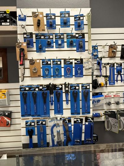 Wall display of packaged bicycle repair tools including wrenches, tire levers, and multi-tools in a retail shop