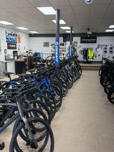 Row of bicycles on showroom floor with Giant branding and gear displays in bike shop