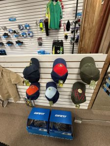 Display of Boy Scouts of America hats and accessories on slatwall in retail shop.