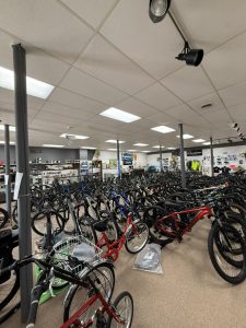 Interior of bicycle shop showroom with rows of bikes displayed for sale.
