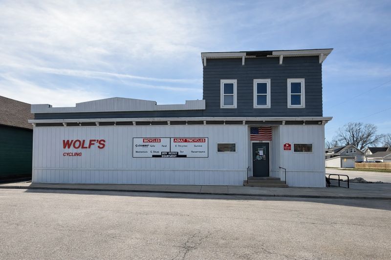 Front exterior of Wolf’s Cycling bike shop building with signage and entrance